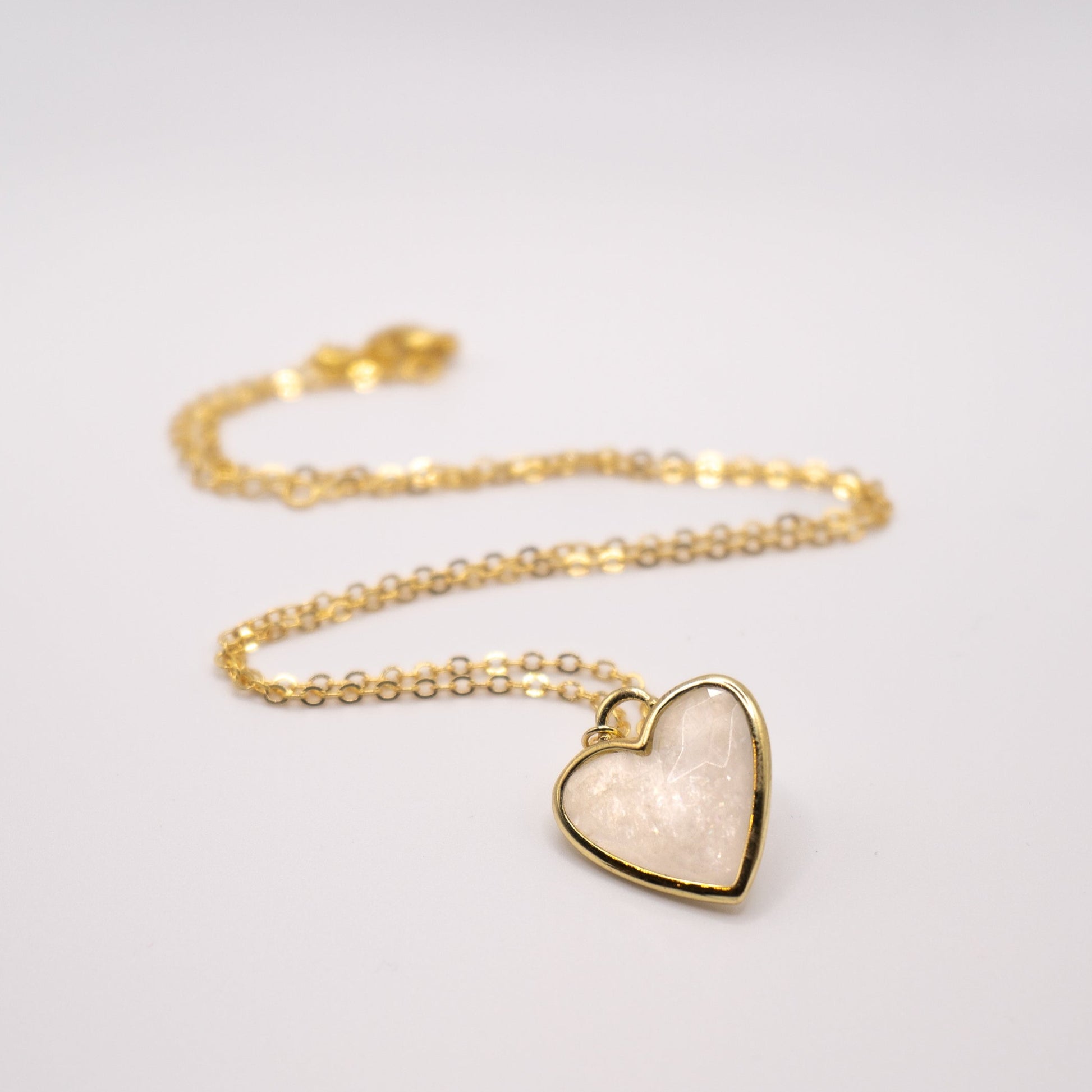 Lula sea Jewellery New Zealand moonstone heart pendant necklace, made from 18k gold and natural facet cut gem stone, vermeil, pictured laying on flat surface